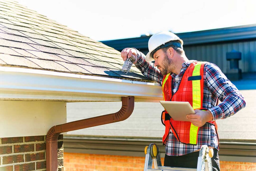Light-colored reflective roof on a home with attic vents under bright summer sunlight.